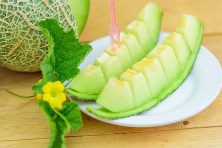 Fresh green melon on wood plateの写真素材
