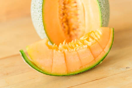 Fresh Orange melon on wood plateの写真素材