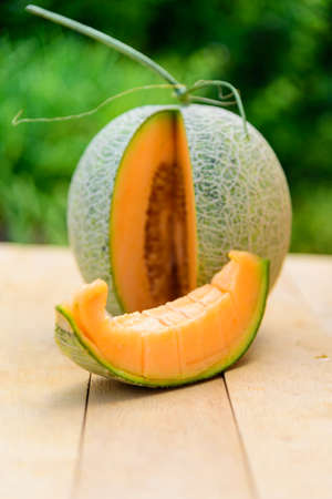 Split Fresh Orange melon on wood plateの写真素材