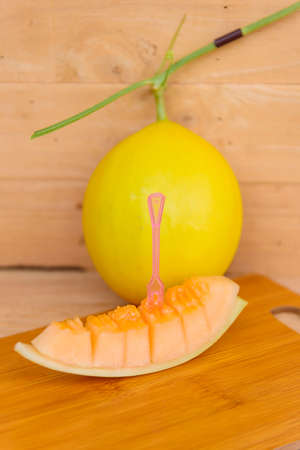 Closeup to fresh golden melon on wood plateの写真素材