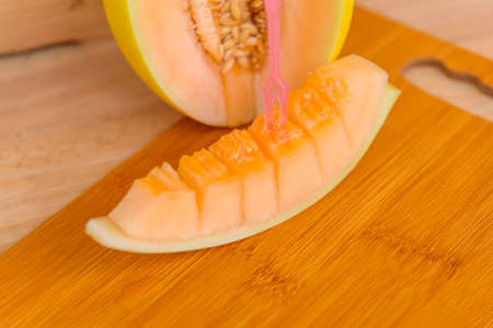 Closeup to fresh golden melon on wood plateの写真素材