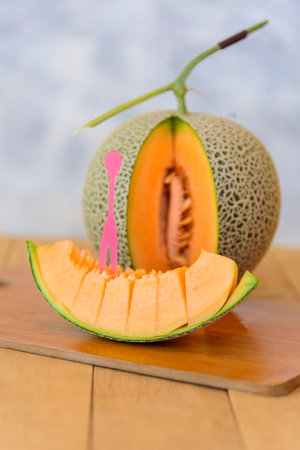 split the orange melon on wood plateの写真素材