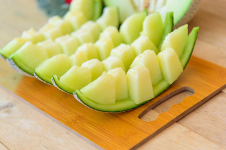 Closeup to Fresh green melon on wood plateの写真素材