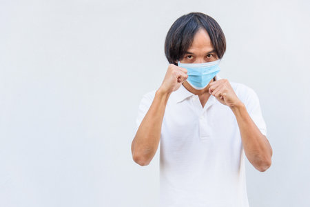 Asian man wear hygienic mask  and post Boxing guard action for fight the diseaseの写真素材