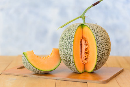 Closeup to split the orange melon on wood plateの写真素材