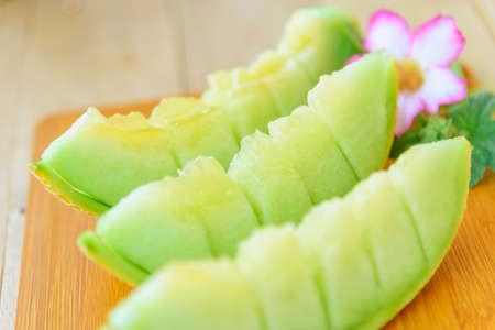 Closeup focus to split the juicy green melon on wood plate