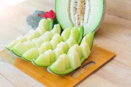 Closeup to Fresh green melon on wood plateの写真素材