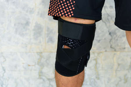 The man wear the Knee Support Brace Patella with sunlight in the park / Knee Pads Hole Sportsの写真素材