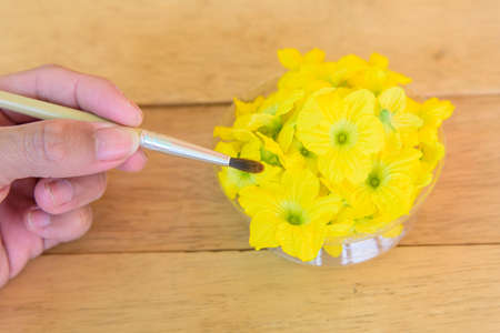 paintbrush and melon flower on wood plate - Item for Pollinate of Melon flowerの写真素材