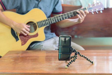 The man live traing the guitar practice streaming by smartphoneの写真素材