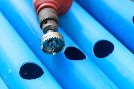 The man use HOLE SAW Perforate the PVC pipe holeの写真素材