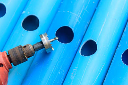 The man use HOLE SAW Perforate the PVC pipe holeの写真素材