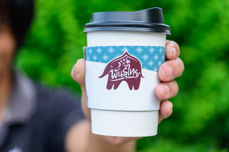 Bangkok,Thailand - 6 April, 2021: The man hold the paper cup of Punthai coffeeのeditorial素材