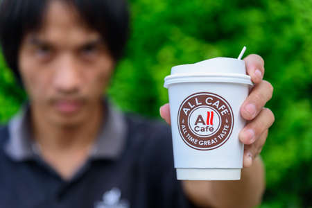 Bangkok,Thailand - 6 April, 2021: The man hold the paper cup of all cafe of hot coffeeのeditorial素材