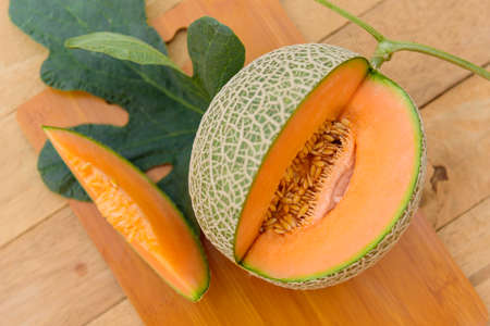 Closeup to split the orange melon on wood plateの写真素材
