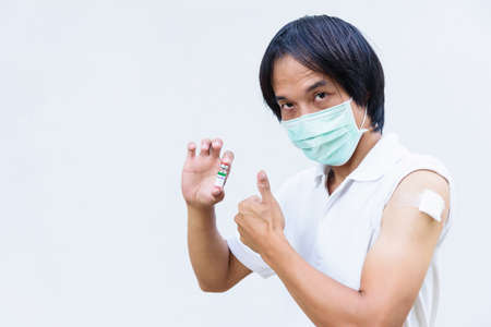 asian man get vaccinated and show his thumb up sign.の写真素材