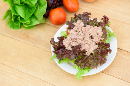 Closeup to tuna salad in the white dish on wood plateの写真素材