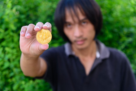 The man show Golden Bitcoin cryptocurrency in his hand