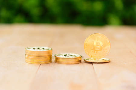 Closeup to Golden Bitcoin cryptocurrency on the wood plateの写真素材