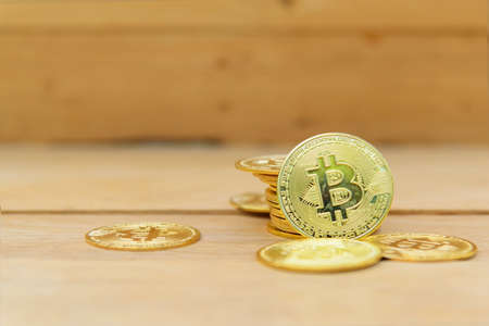 Closeup to Golden Bitcoin cryptocurrency on the wood plateの写真素材