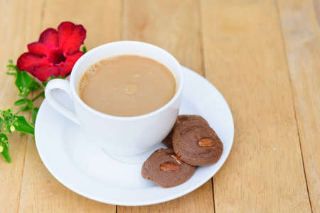 Top view of hot coffee with cookie on wood plateの写真素材