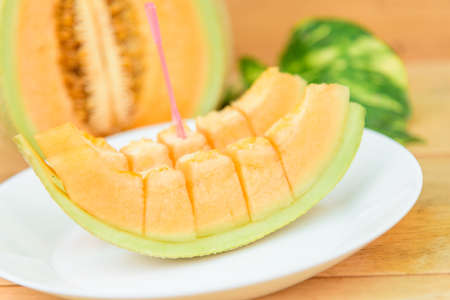 a lot of piece of fresh orange melon on the plateの写真素材