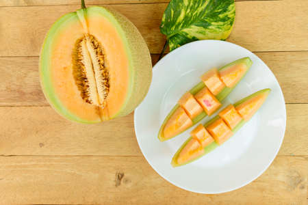 a lot of piece of fresh orange melon on the plateの写真素材