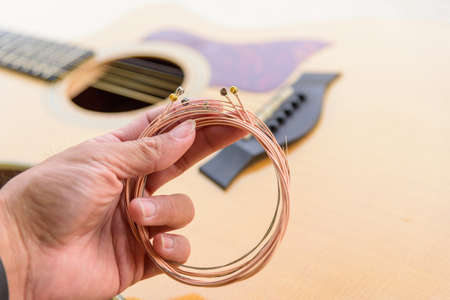 The musician replace the new guitar strings for his guitarの写真素材