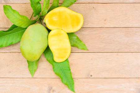 Closeup to yellow mango on the wood plateの写真素材