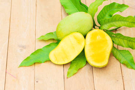 Closeup to yellow mango on the wood plateの写真素材