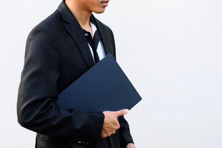 Businessman holding a laptop computer on white background with copy space.の写真素材