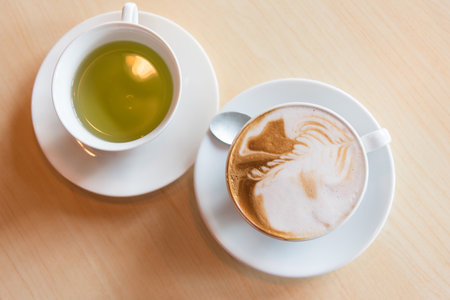 hot cappuccino coffee with green tea on tableの写真素材