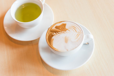 hot cappuccino coffee with green tea on tableの写真素材