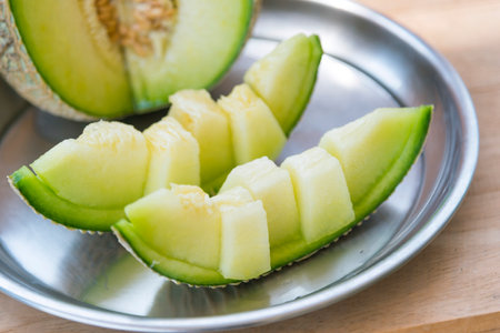 a lot of piece of fresh green melon on the plateの写真素材