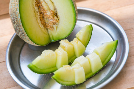Fresh green melon on metal plateの写真素材