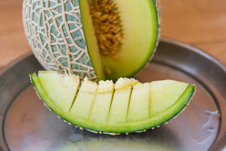 Closeup to Fresh green melon on wood plateの写真素材