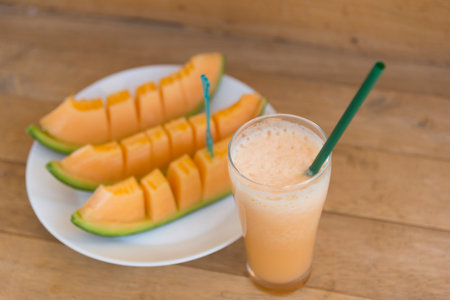Melon smoothie in a glass on the wooden table, stock photoの写真素材