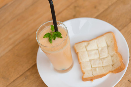 Milk melon Smoothie in glass with breadの写真素材