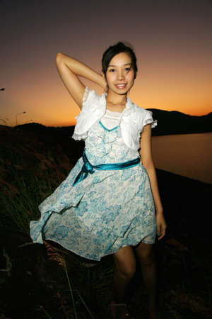 young pretty woman in Beautiful dress with sunset backgroundの写真素材