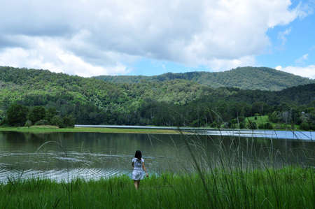 Young moman walk down to the lakeの写真素材