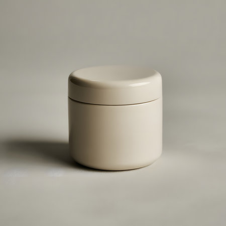 A simple, elegant, and minimalist beige cosmetic jar with a subtle metallic band sits on a neutral gray background, evoking a sense of luxury and skincareの素材