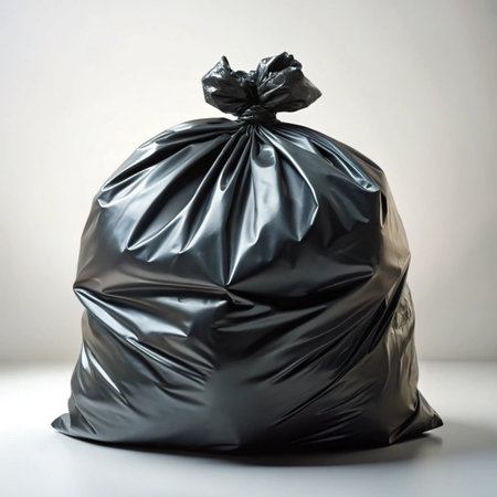 A large, black garbage bag tied shut, full of trash, isolated on a white backgroundの素材