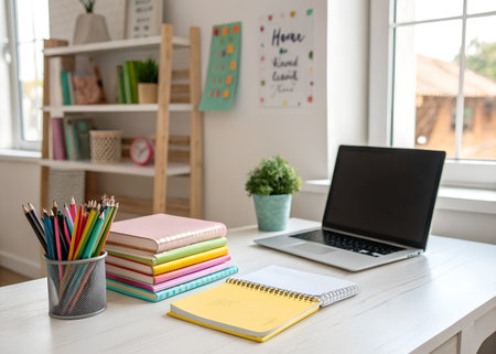 Close up of a desk with laptop, books and stationery.の素材