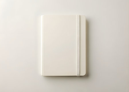 A clean, closed, lightcolored notebook with an elastic band closure, perfect for journaling, notetaking, sketching, or organizing thoughts on a plain backgroundの素材
