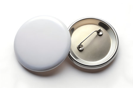 A blank white round pin button and its back with a safety pin closure, isolated on a white background, perfect for custom designs and promotional merchandiseの素材