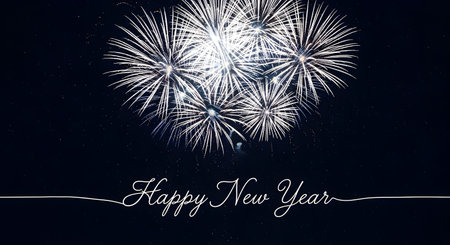 Bright white fireworks display against dark night sky with happy new year textの素材