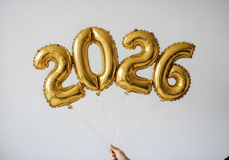 Golden balloons spell out the year 2026 against a white backgroundの素材