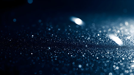 Sparkling blue bokeh abstract background with shimmering glitter and glowing light reflections creating a magical cosmic atmosphereの素材