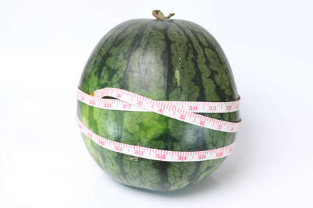 Watermelon with measuring the length around on a white background.の写真素材