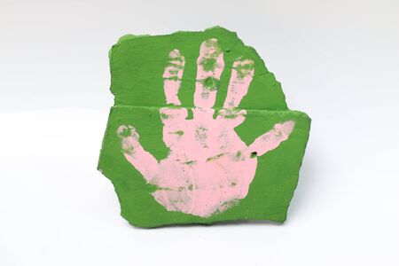 A baby pink pumps and hand down a green stone flooring.の写真素材